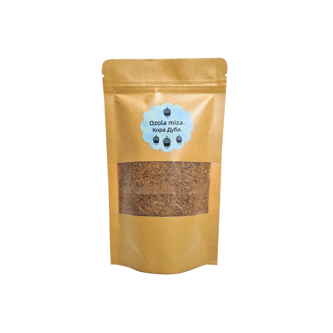 Ozola mizas pulvera iepakojums (amatnieku papīra stāvpaka) ar caurspīdīgu lodziņu un zilu etiķeti ar tekstu "Ozola miza." (latviski) un "Кора Дуба." (krieviski), izolēts uz balta fona.
