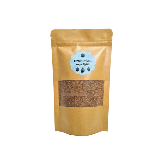 Ozola mizas pulvera iepakojums (amatnieku papīra stāvpaka) ar caurspīdīgu lodziņu un zilu etiķeti ar tekstu "Ozola miza." (latviski) un "Кора Дуба." (krieviski), izolēts uz balta fona.