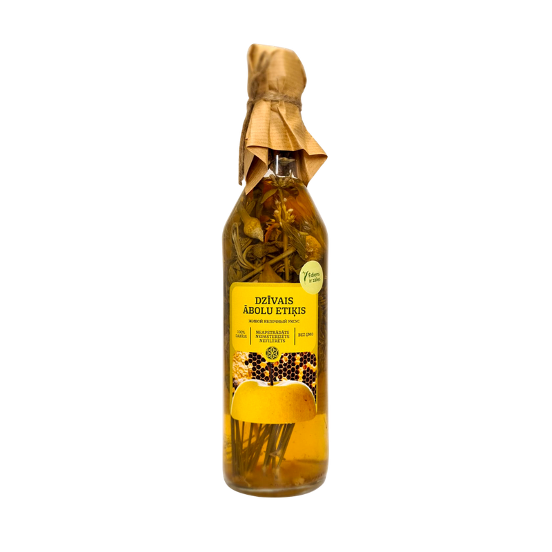 Dabīgs dzīvais ābolu etiķis ar dārza garšaugiem stikla pudelē.